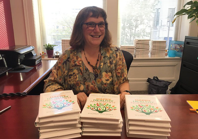 Beth with copies of the networked nonprofit on a desk in front of her