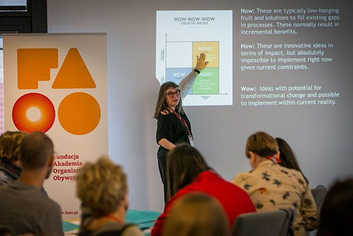 Beth teaching a workshop, pointing to a slide